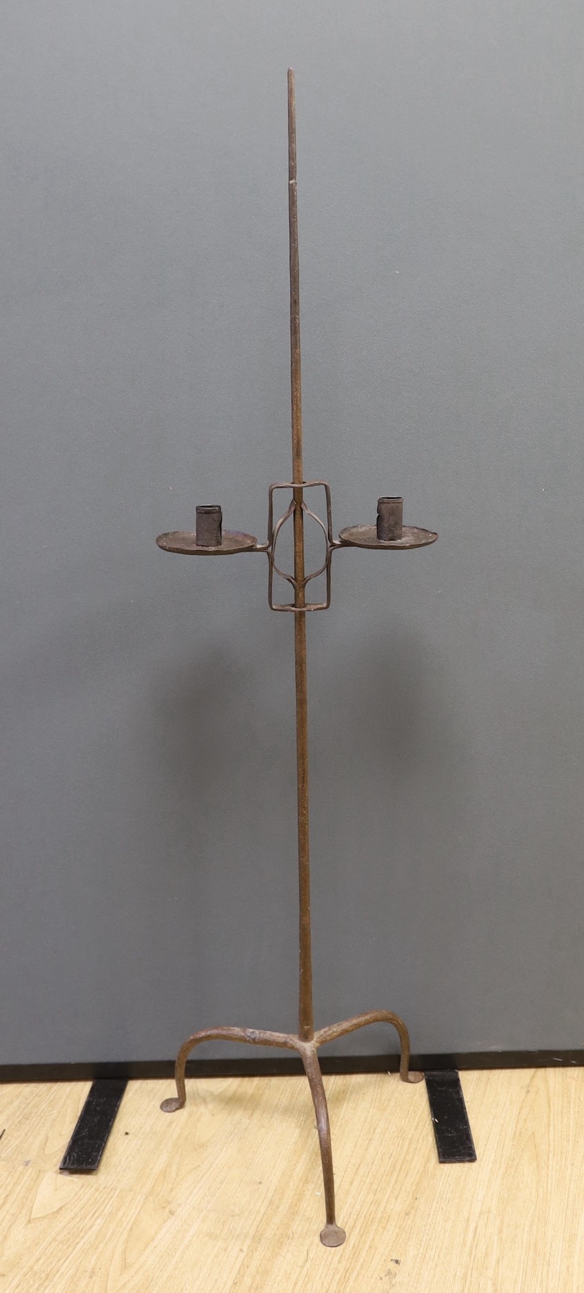 An 18th century wrought iron tripod candle stand 135cm